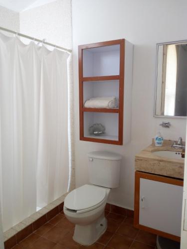 a bathroom with a toilet and a sink and a mirror at Camino al Mar in Santa Cruz Huatulco