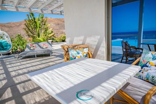 a table and chairs on a patio with a view of the ocean at Etti - Paradise Suite La Gaviota in Pájara