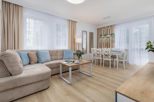ein Wohnzimmer mit einem Sofa und einem Tisch in der Unterkunft Baltini Premium Apartament Old Town in Kołobrzeg