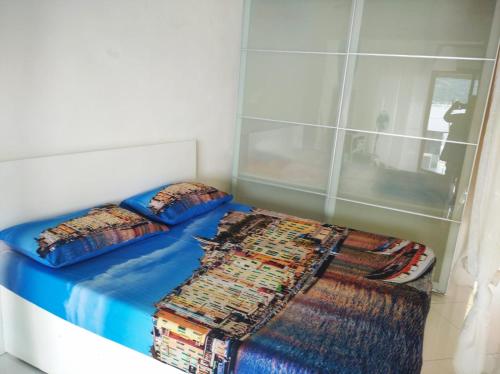 a bed in a room with two pillows and a blanket at appartamento openspace fronte mare esclusivo due letti matrimoniali a Portovenere in Portovenere