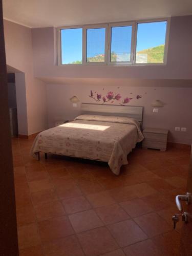 sypialnia z łóżkiem w pokoju z 2 oknami w obiekcie Casa dello Yoga w mieście Colonnella
