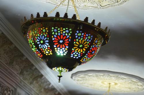 a stained glass chandelier hanging from a ceiling at Riad Selma in Meknès
