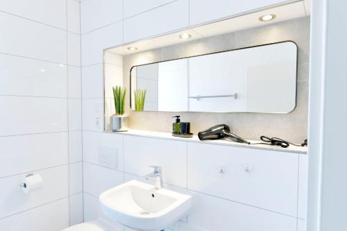 Baño blanco con lavabo y espejo en Luxus Apartment Gronau - direkte Nähe zu Enschede, en Gronau