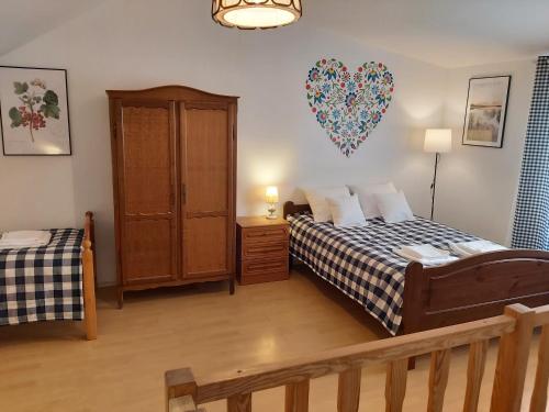 a bedroom with two beds and a heart balloon on the wall at Pokoje Podzamcze in Stare Drawsko