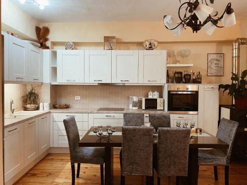 uma cozinha com armários brancos e uma mesa com cadeiras em Andreas Village 2 em Achladies
