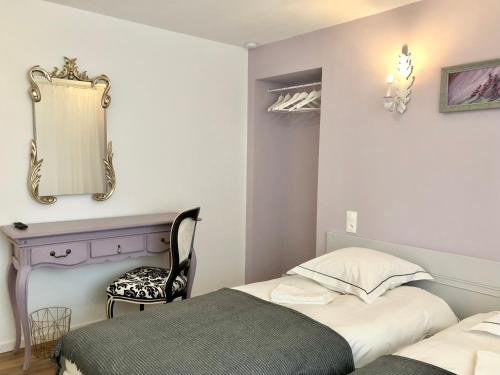 a bedroom with a bed and a mirror and a chair at Hôtel D’Artiste in Pierrefontaine-les-Varans