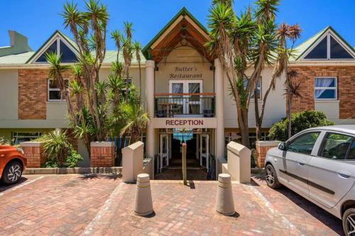 a white car parked in front of a hotel at Modern apartment, a home away from home right next to the beachfront in Summerstrand