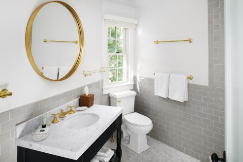a bathroom with a sink and a toilet and a mirror at The Pridwin Hotel in Shelter Island