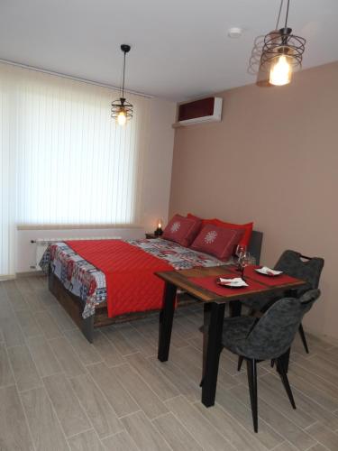 una camera con letto e tavolo con coperta rossa di Vintage Studio Mladost a Sofia
