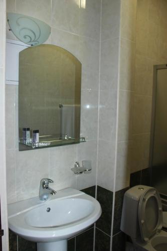 a bathroom with a sink and a mirror at Hotel Laeti-Zhaiyk in Atyraū