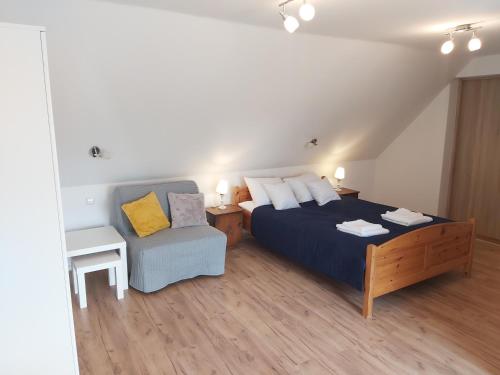 a bedroom with a bed and a chair at Pokoje Podzamcze in Stare Drawsko