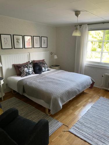 a bedroom with a bed and a chair and a window at Yaberg Affären in Hyltebruk