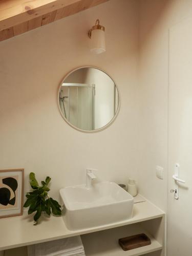 a white bathroom with a sink and a mirror at Vasantina Kamena Kućica in Mala Čista