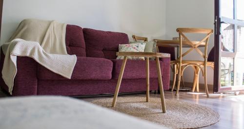 a living room with a purple couch and a table at Luz del Tajo in Alcántara