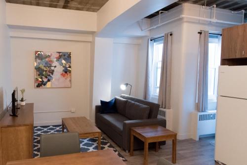 a living room with a couch and a table at Le Central in Rouyn