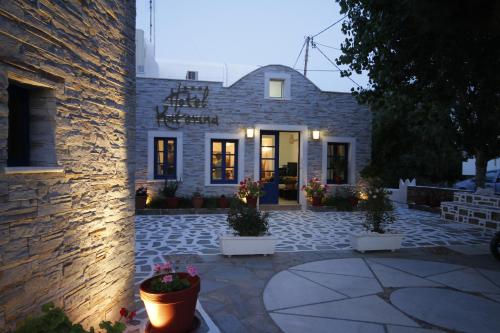a stone building with a sign on the front of it at Katerina Hotel in Agios Prokopios
