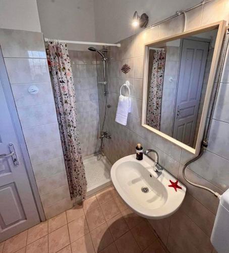 a bathroom with a sink and a shower at Holiday House Ermionida in Thermisia