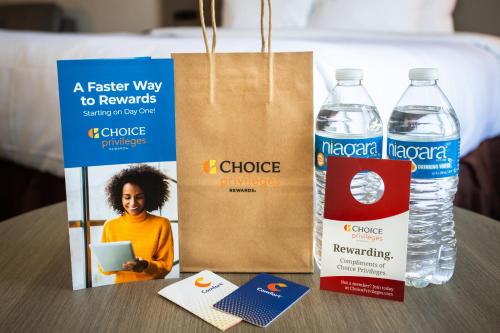 a table with two bottles of water and a paper bag at Comfort Inn & Suites Buffalo Airport in Buffalo