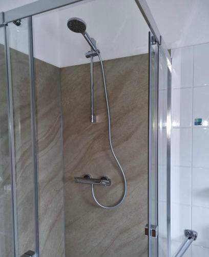 a shower with a shower head in a bathroom at Ferienhaus Heimathafen Neßmersiel in Neßmersiel