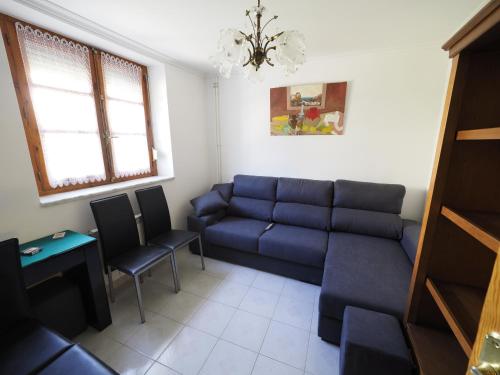 a living room with a blue couch and chairs at CASA PURI - ACOGEDORA CASA CON PARKING y PATIO INTERIOR in Robles de la Valcueva