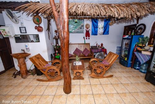 a room with chairs and a table and a thatch roof at Hotel y Restaurante La Cabaña el Viajero in Castillo de San Felipe