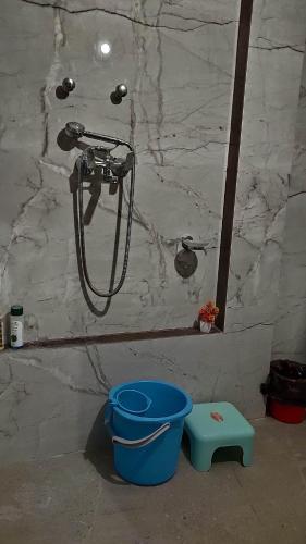 a shower in a bathroom with a bucket next to a bucket at Ira Homestay Mathura - Divine Spiritual Stay in Mathura