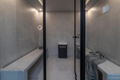 a bathroom with two benches and a trash can at Villa drys II in Elliniká