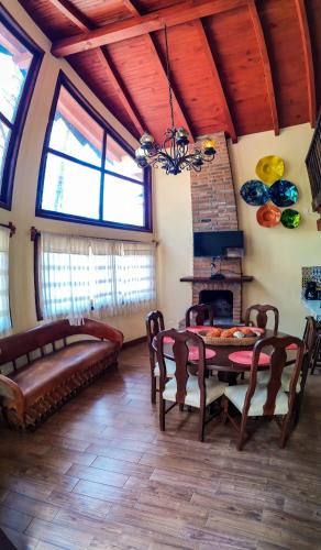 a living room with a table and a fireplace at Cabañas Las Morenas Mazamitla in Mazamitla