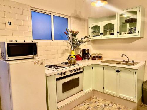 a kitchen with a white refrigerator and a microwave at Amazing Cozy Apartment in Condesa in Mexico City