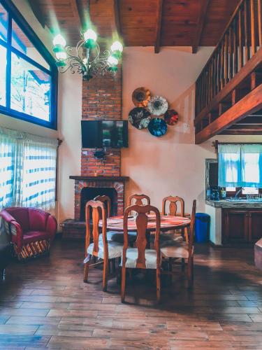 a dining room with a table and chairs and a fireplace at Cabañas Las Morenas Mazamitla in Mazamitla
