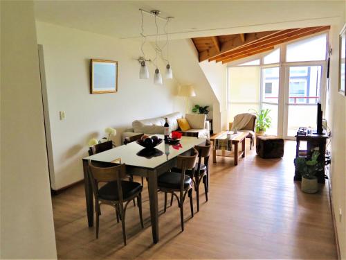 ein Esszimmer und ein Wohnzimmer mit einem Tisch und Stühlen in der Unterkunft Bariloche Lake View Apartments in San Carlos de Bariloche