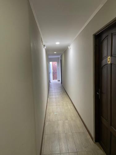 an empty hallway with a door and a tile floor at Loft & Suites Centro in Salto