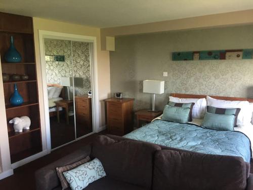 um quarto com uma cama grande e um sofá em Ullswater Suite em Penrith