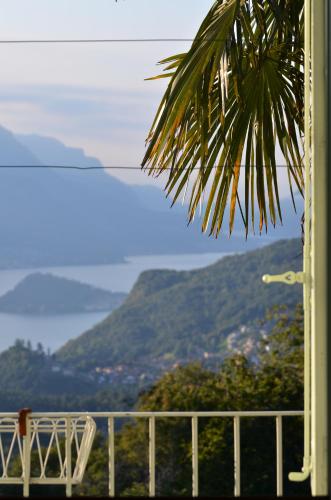 a balcony with a chair and a view of mountains at Casa Lario in Naggio