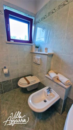 a bathroom with a toilet and a sink at Villa Azzurra in Umag