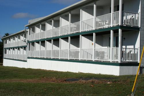 a white building with balconies on the side of it at Windrifter Resort in Wolfeboro