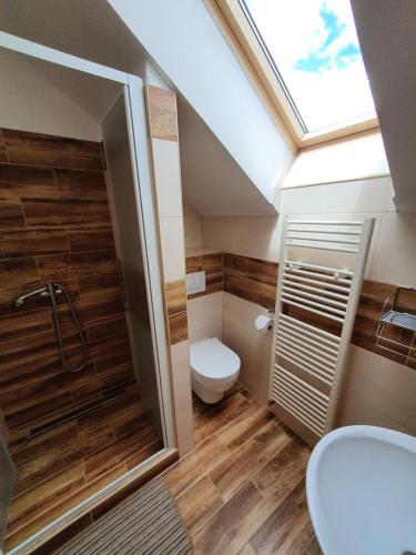 a bathroom with a toilet and a shower with a skylight at Apartmány Ďurik in Liptovský Mikuláš