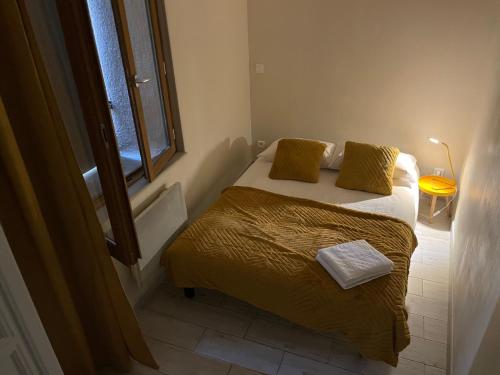 um quarto com uma cama com lençóis amarelos e uma janela em Location de vacances Rians haut Var em Rians