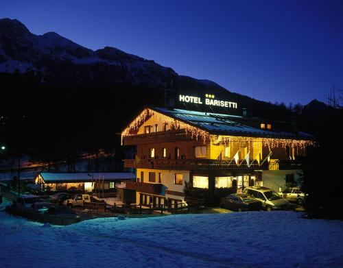 a hotel with cars parked in front of it at night at Barisetti Sport Hotel in Cortina dʼAmpezzo