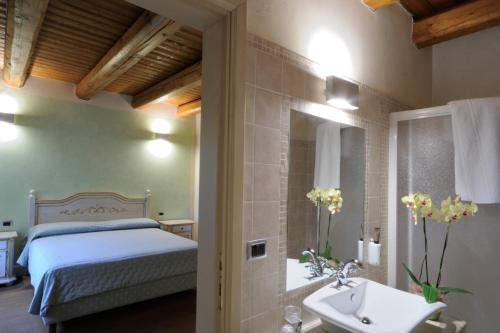 a bedroom with a bed and a sink and a mirror at Agriturismo I Leprotti in Abbiategrasso