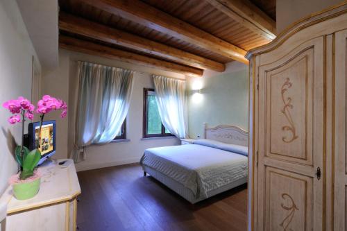 a bedroom with a bed and a dresser with pink flowers at Agriturismo I Leprotti in Abbiategrasso