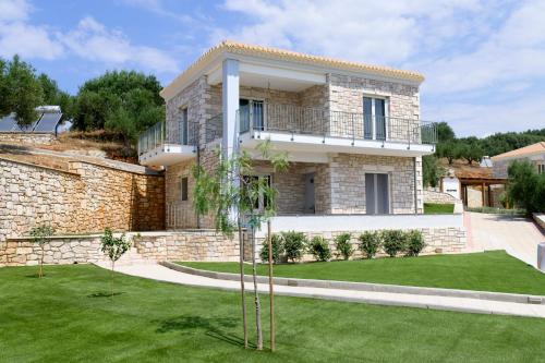 a large stone house with a green yard at ALMA HILLS Gialova in Gialova