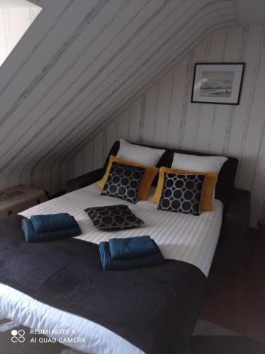 uma cama com almofadas num quarto em La Gravière 