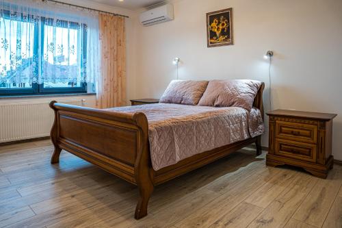 um quarto com uma cama, uma mesa de cabeceira e uma janela em Apartamenty Na Szlaku 