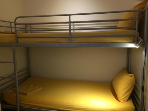 a room with two bunk beds with a yellow pillow at Mondello Luxury Apartment on the Beach in Mondello
