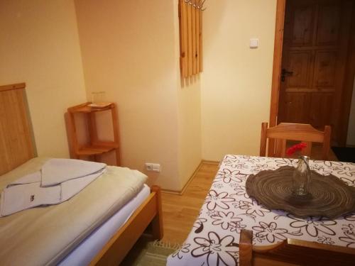 a small room with a bed and a table with at Pod palmou Gerlachov in Gerlachov