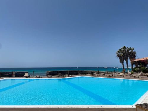 une grande piscine avec la plage en arrière-plan dans l'établissement Porto Antigo 1 - Beach apartments, à Santa Maria