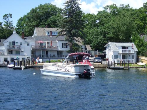 a boat is docked in the water near houses at Windrifter Resort in Wolfeboro