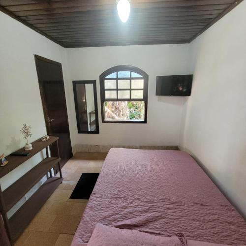 a bedroom with a large bed and a window at Pousada do Arthur in Ilha do Mel