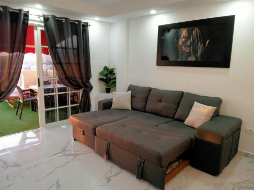 ein Wohnzimmer mit einem Sofa und einem TV in der Unterkunft Balcon Atlantico Holiday Tenerife in Adeje